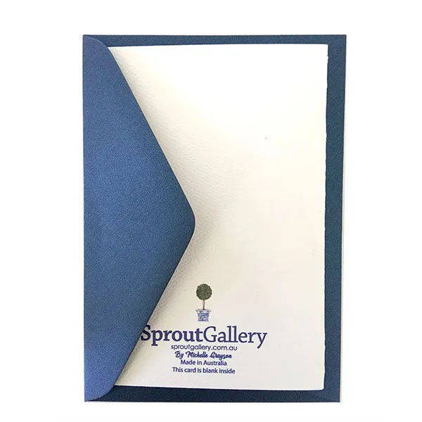 A blue and white card with topiary trees
